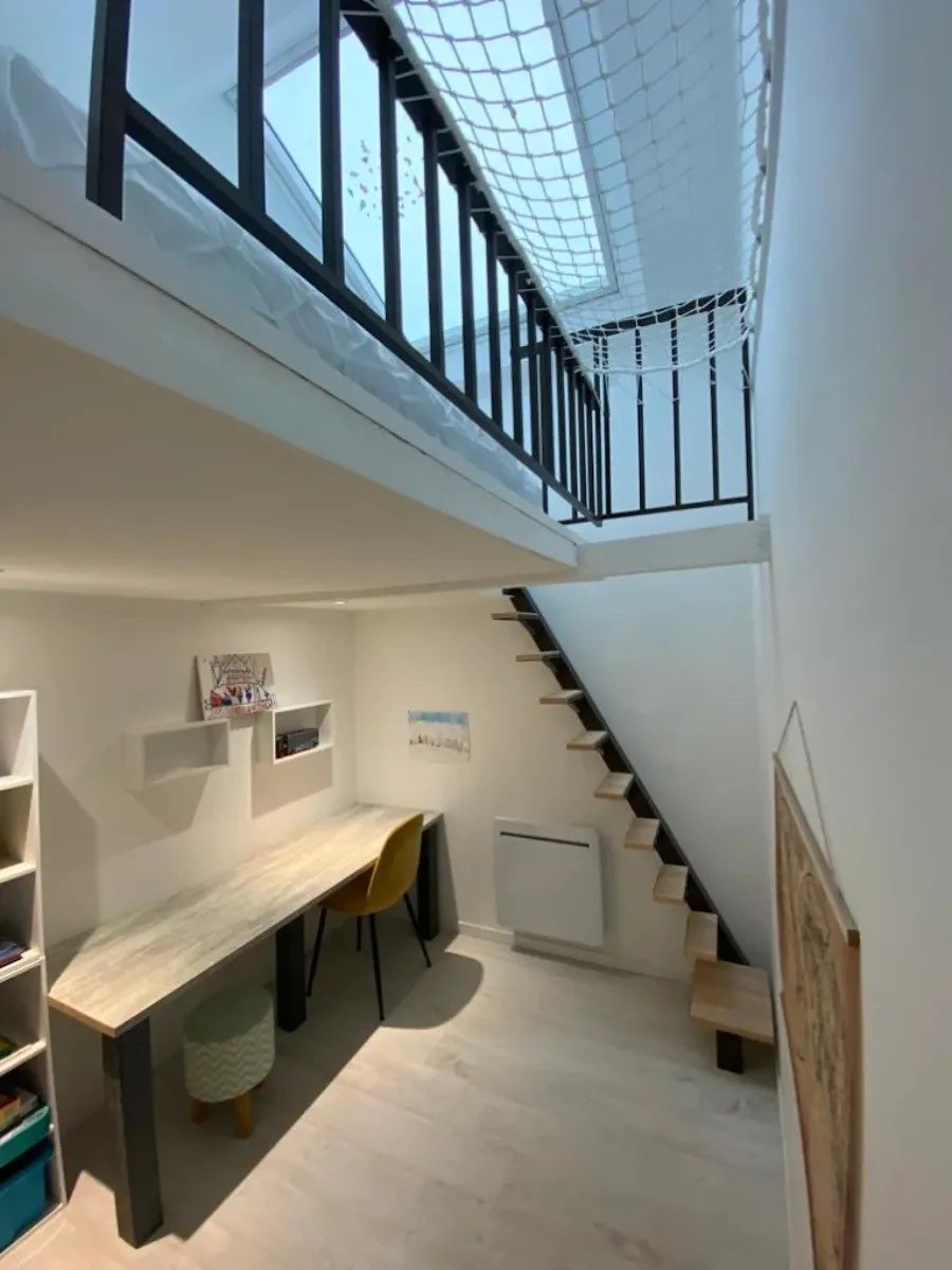 Logement rénové avec mezzanine, escalier bois et métal, coin bureau sur mesure et sol clair