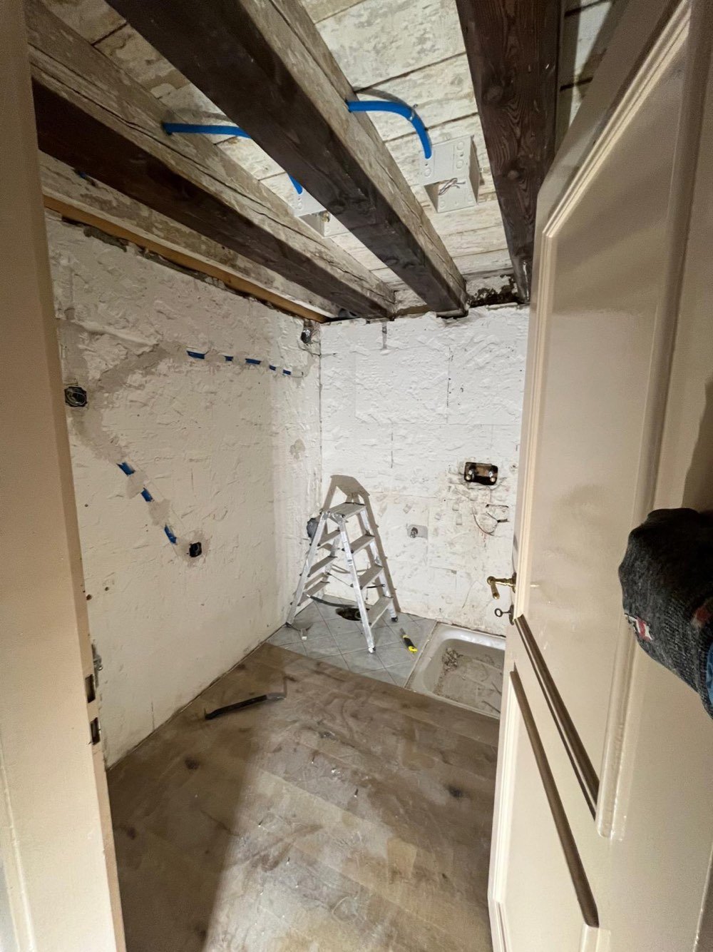 Pièce mise à nu · ancien carrelage et baignoire déposés · réseaux repris